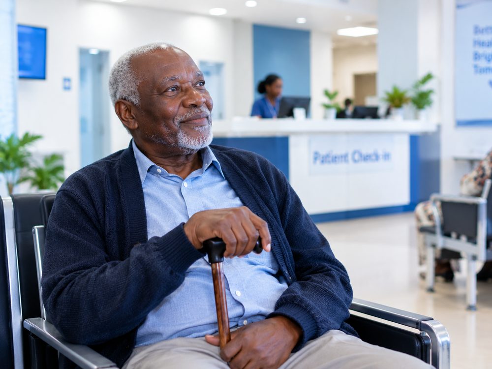 An older man smiling as he waits for his appointment